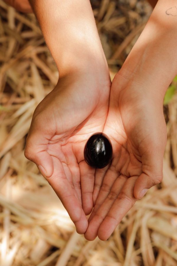 huevo yoni obsidiana mano